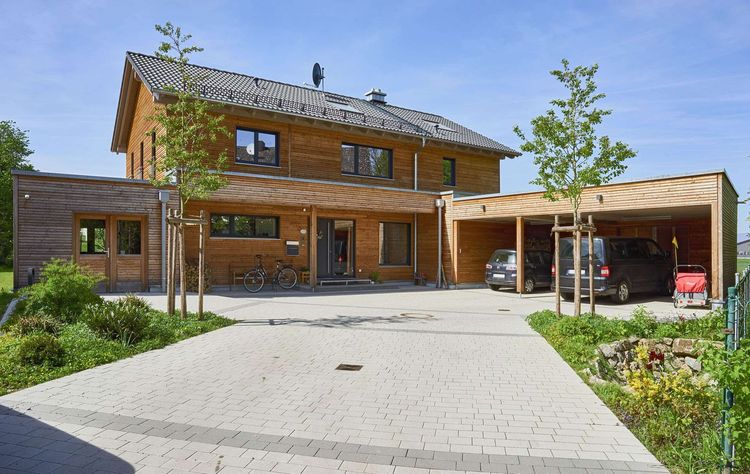 Modernes Fertighaus mit Satteldach, Holzverschalung und Carport