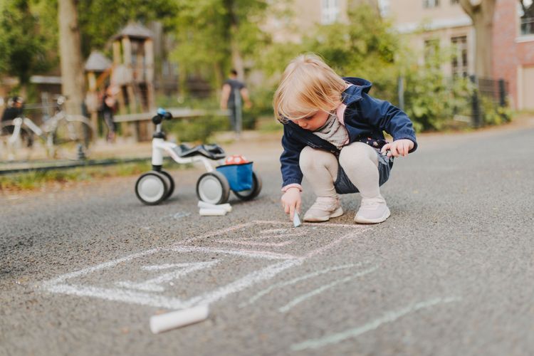 Junges Mädchen spielt auf der Straße