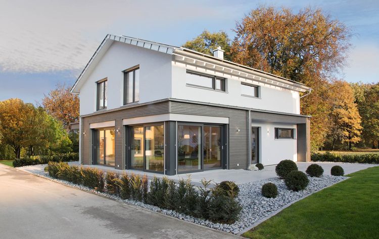 Ein Satteldach, viele bodentiefe Fenster und kubische Fassadenakzente geben diesem modernen Haus einen unverwechselbaren Charakter.