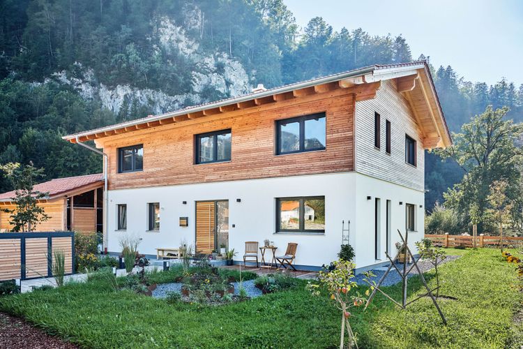 Modernes Landhaus im Alpenstil mit Satteldach und Holzerschalung