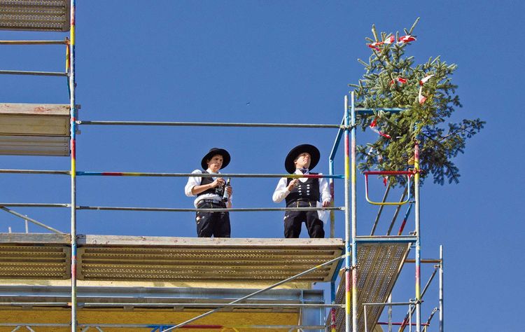 Handwerker auf dem Baugerüst beim Richtfest