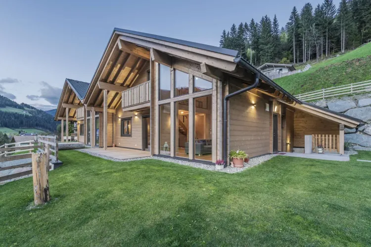 Modernes Holzhaus am Hang mit bodentiefen Fenstern