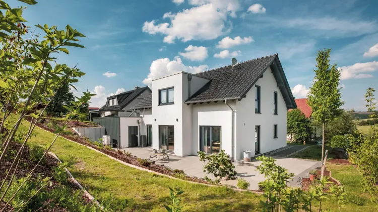 Modernes Fertighaus mit Satteldach, Zwerchhaus und Wärmepumpe