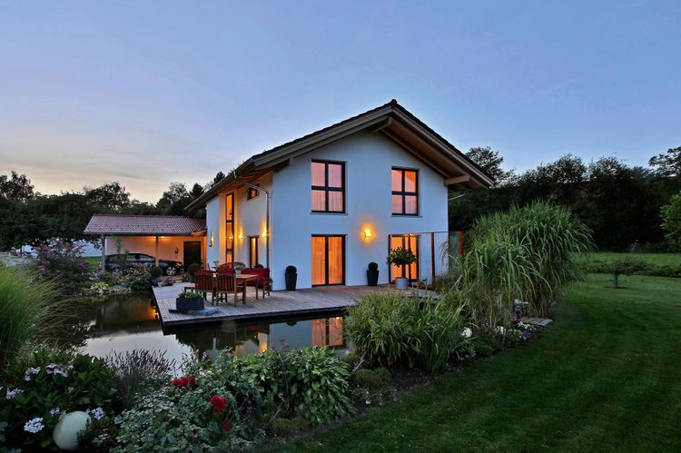 Modernes Einfamilienhaus von Regnauer mit Satteldach, Terrasse und Teich im Garten