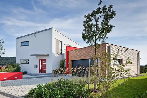 Modernes LUXHAUS Fertighaus im Kubusstil mit Pultdach und Anbau