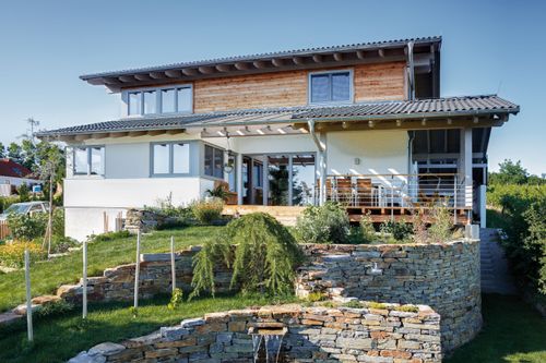 Modernes Holzhaus im Landhausstil auf einem Hanggrundstück