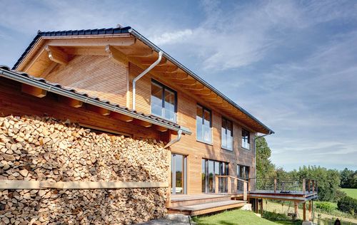 Modernes Holzhaus im Landhausstil mit durchgängiger Holzfassade