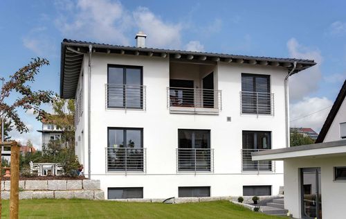 Modernes Stadthaus aus Holz mit mineralischem Außenputz und Loggia