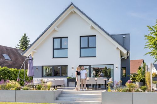 Bauherren auf der Terrasse ihres Einfamilienhauses