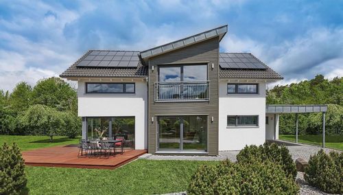 Außenansicht des Fertighaus WEISS Plusenergiehauses in Erlangen mit Sattel- und Pultdach und großer Terrasse